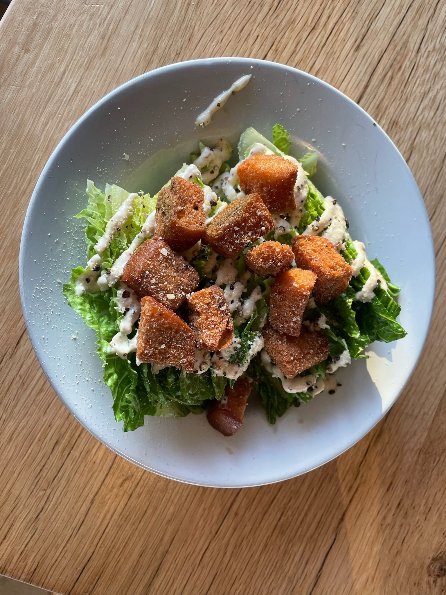 caesar salad in a white bowl