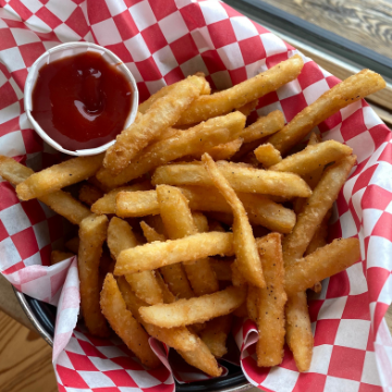 fries in a basket lined with red and white wax paper